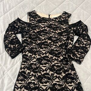 Black lace “cold shoulder” dress. Sheer black lace over a cream liner. Back zip.